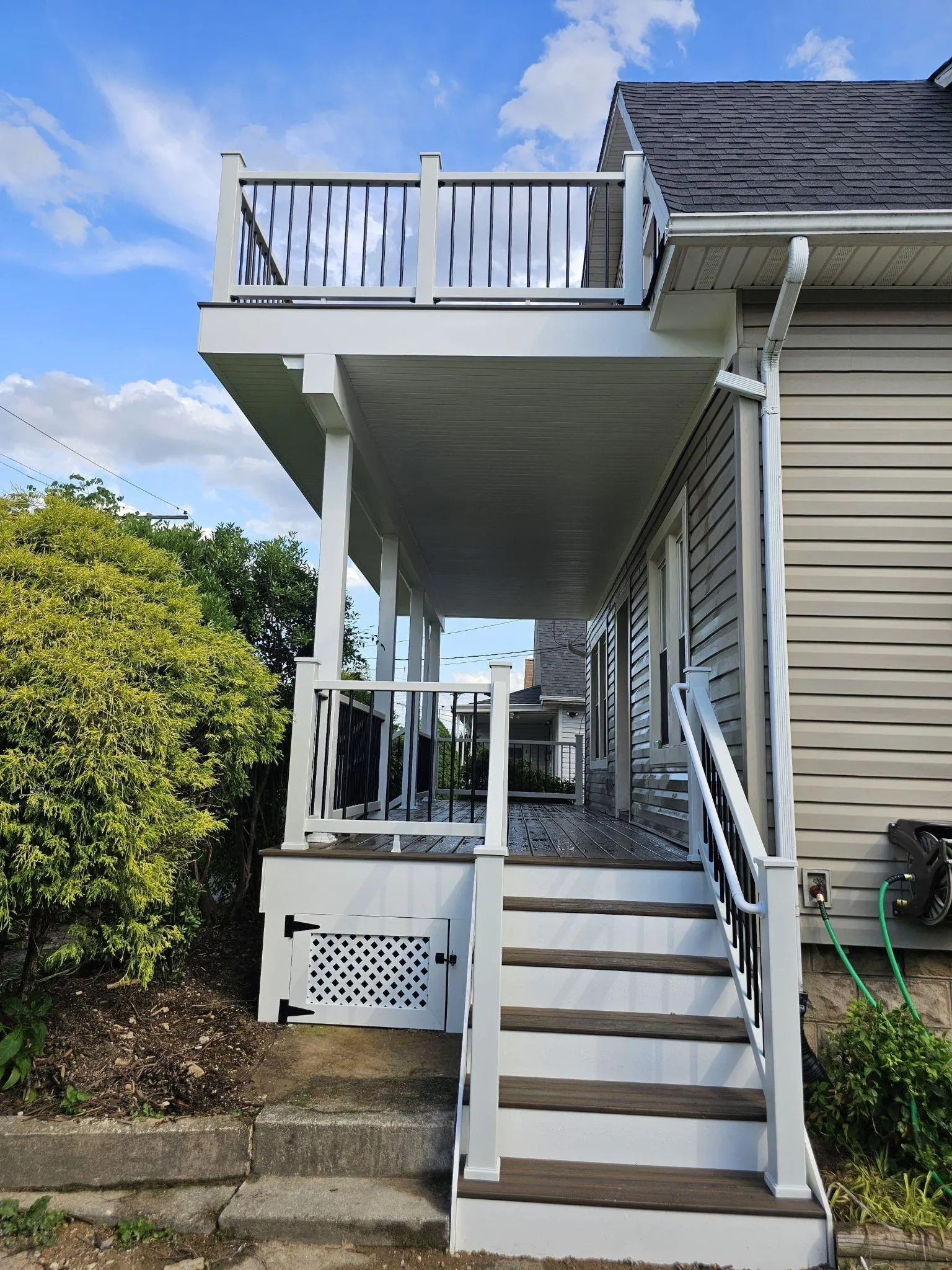 Side view after the porch and upper deck rebuild with new stairs and railings