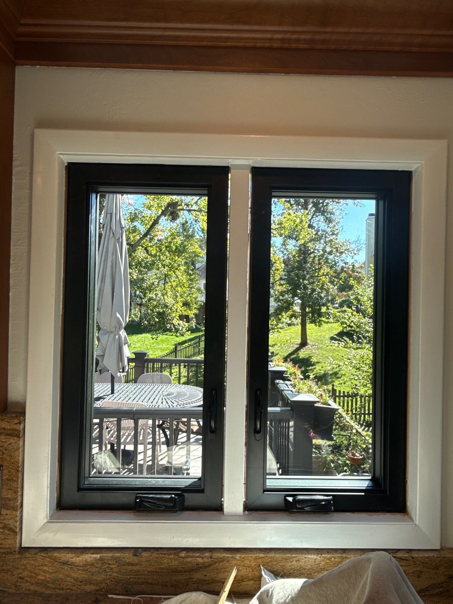 Kitchen window facing the deck before and after replacement with black casement windows in Ellicott City, Maryland