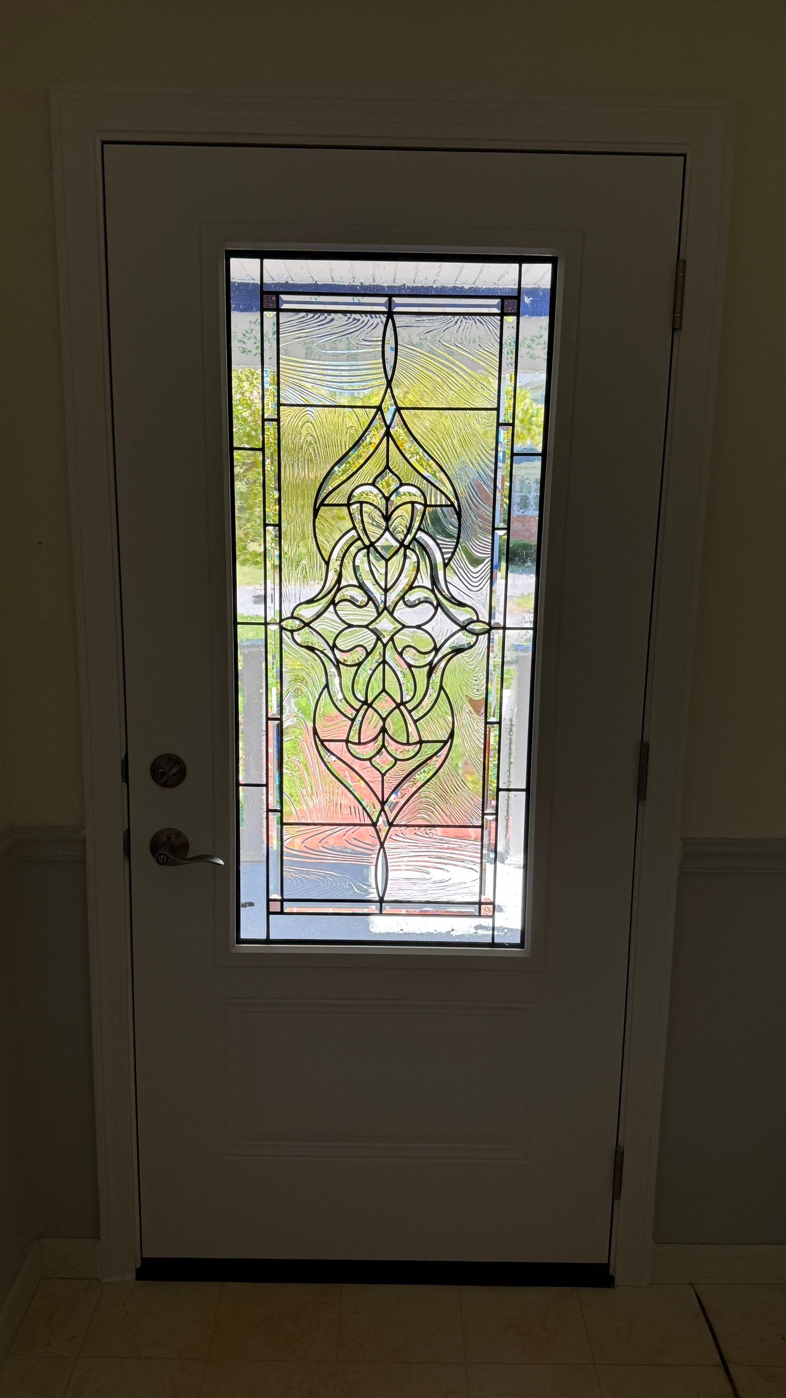 Interior view of a ProVia Legacy smooth steel entry door in Snow Mist White with decorative glass.